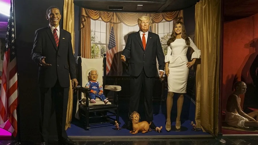 Artista chileno colocó un perro faldero con la cara de Milei, a los pies de una figura de Trump