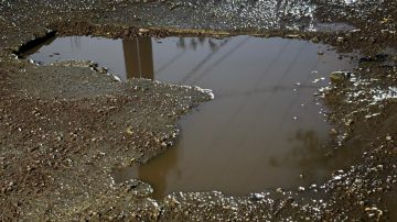 Vecinos denuncian que un enorme pozo en calle Lamadrid provocó accidentes y exigen su reparación