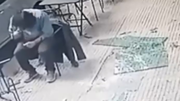 VIDEO | Se desprendió el vidrio de un balcón y le cayó en la cabeza a un hombre que comía en un bar