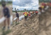 Guardavidas trabajan en el armado de bolsas de arena para reforzar las defensas del río Dulce