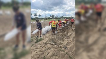 Guardavidas trabajan en el armado de bolsas de arena para reforzar las defensas del río Dulce